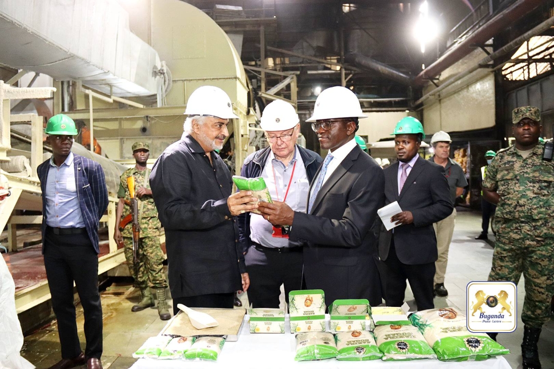 The Managing Director of Madhvani Group showing the Katikkiro the sugar produced by the company